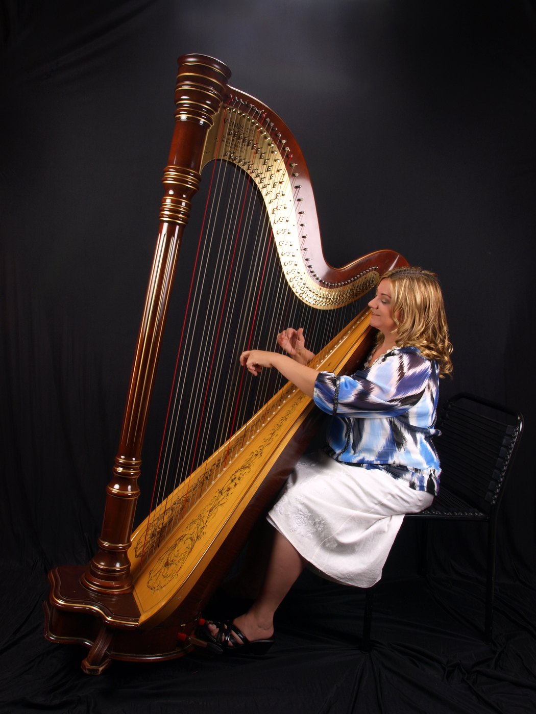 Patricia as a girl, playing a full concert pedal harp